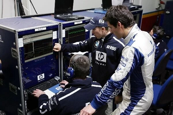 Formula One Testing: Nick Heidfeld Williams and team mate Mark Webber Williams study telemetry from the Williams FW27 on the computers in the