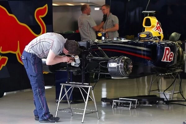 Formula One Testing: A Red Bull mechanic works on the teams car for tomorrows testing