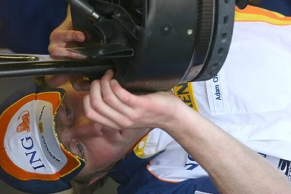 Formula One Testing: A Renault mechanic works on the wheel of the Renault R27