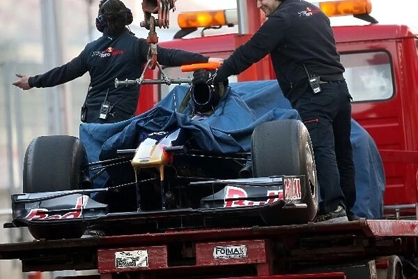 Formula One Testing: Scuderia Toro Rosso STR4 is bought back to the pits on a truck