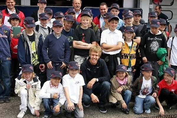 Formula One Testing: Sebastian Vettel Scuderia Toro Rosso with young visitors to the pit lane