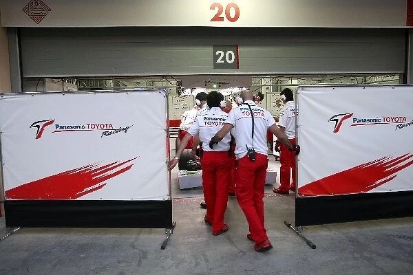 Formula One Testing: Toyota mechanics quickly pull the screens across the garage