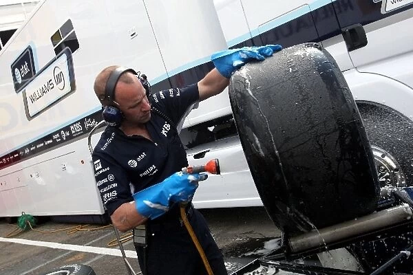 Formula One Testing: Used slick tyres and wheels are washed by a Williams team member