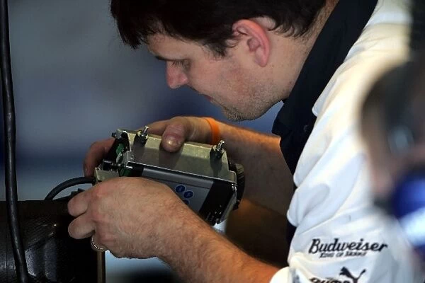 Formula One Testing: A Williams mechanic dismantles the data recorder that was attached to the car of Nico Rosberg