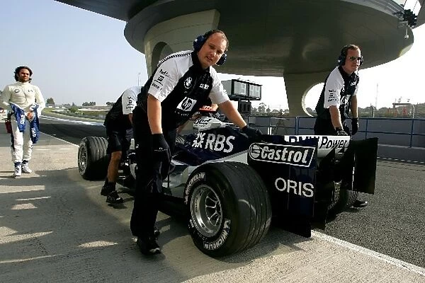 Formula One Testing: Williams mechanics push the V8 powered Williams back down the pit lane