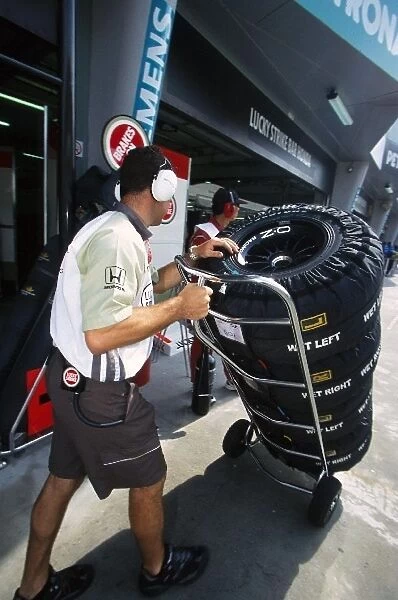 Formula One World Championship: A BAR mechanic picks up tyres with their warmers fitted