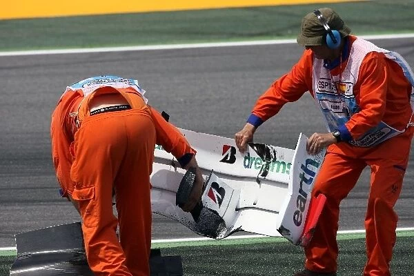 Formula One World Championship: The broken front wing of Rubens Barrichello Honda RA108 is removed from the track by marshalls