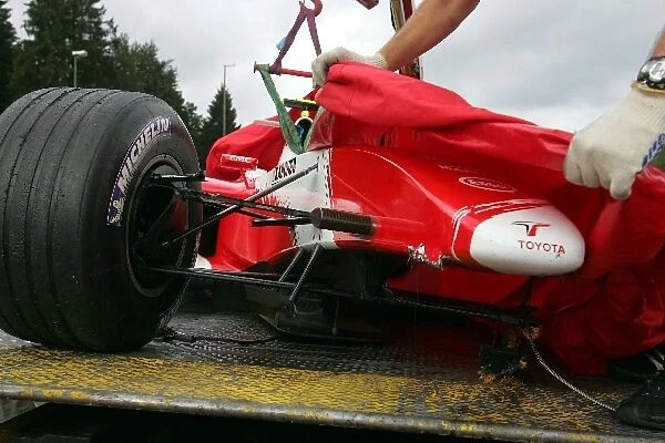 Formula One World Championship: The car of Ryan Briscoe Toyota TF104B is returned to the pits on a truck after a crash at Eau Rouge