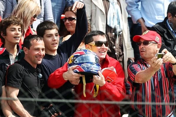 Formula One World Championship: A child in the crowd catches the helmet of race winner Mark Webber Red Bull Racing