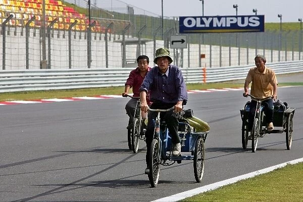 Formula One World Championship: Circuit workers cycle the circuit