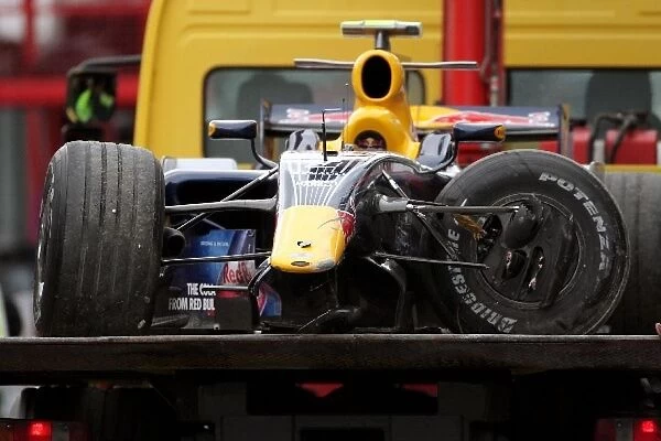 Formula One World Championship: The damaged car of Mark Webber Red Bull Racing RB4 is returned to the paddock on a truck