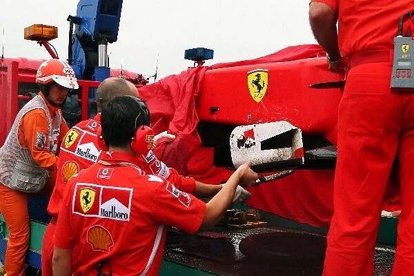 Formula One World Championship: The damaged Ferrari F2005 of Michael Schumacher is returned to the pits after he crashed during practice