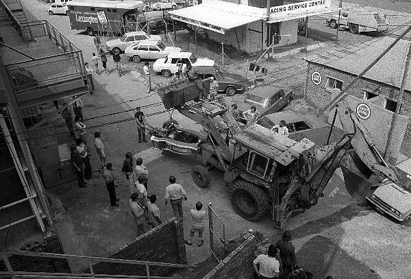 Formula One World Championship: The damaged Ligier JS5 of Jacques Laffite is returned to the paddock using a digger during practice