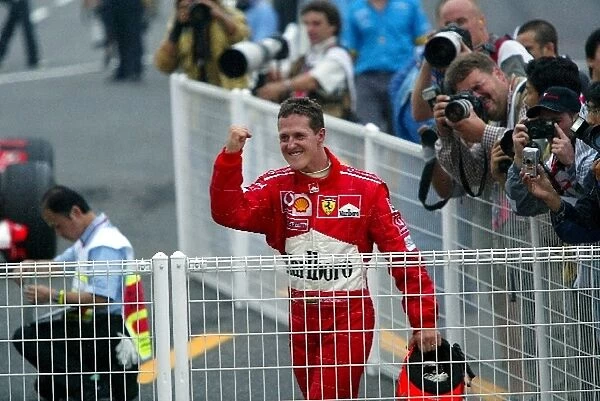 Formula One World Championship: Eighth placed Michael Schumacher Ferrari celebrates his sixth world Championship title in Parc Ferme after taking