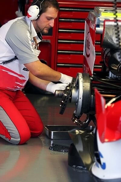 Formula One World Championship: Engineer works on the brakes of a Toyota TF106