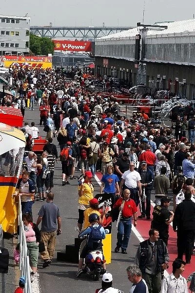 Formula One World Championship: Fans walk about the pit lane