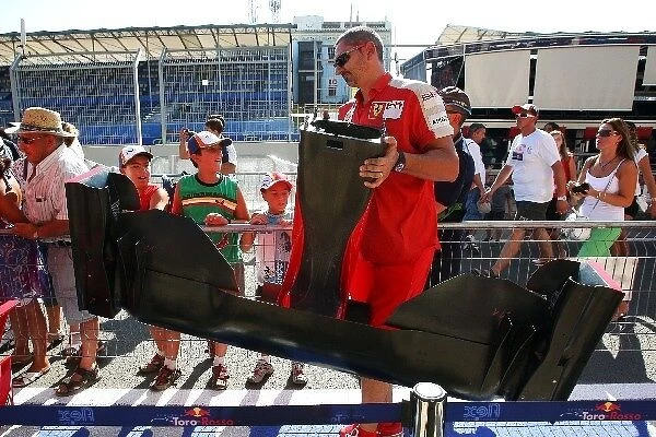 Formula One World Championship: Ferrari carry car parts through the pit lane