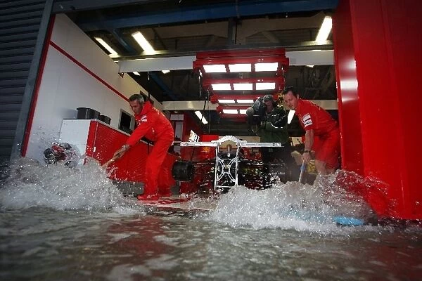 Formula One World Championship: The Ferrari pit garage is flooded during a storm in first practice