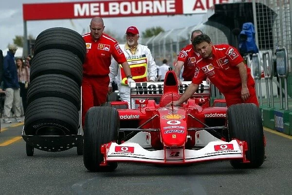 Formula One World Championship: The Ferrari team take their car back to the McLaren garage under supervision from scrutineers