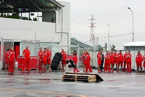 Formula One World Championship: The Ferrari team play with a remote control car in the paddock