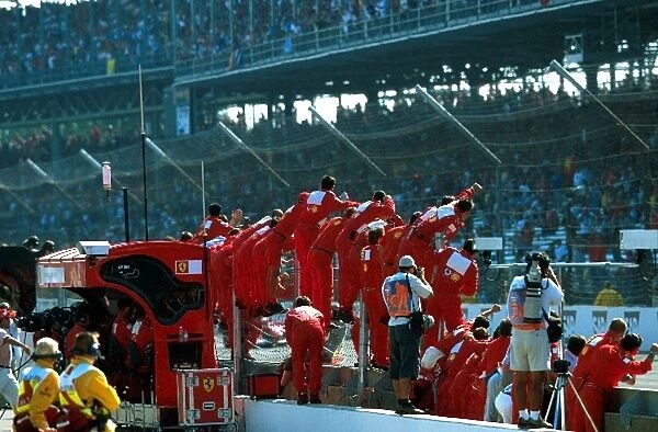 Formula One World Championship: The Ferrari team stand on the pit wall to celebrate what was to be a controversial 1-2 finish