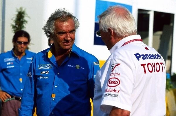 Formula One World Championship: Flavio Briatore Renault Team Principal talks with Ove Andersson Toyota F1 Team President in the paddock