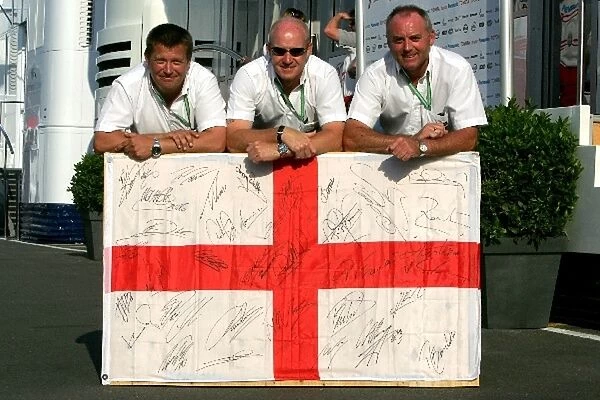 Formula One World Championship: FOM staff with an England flag signed by drivers and stars