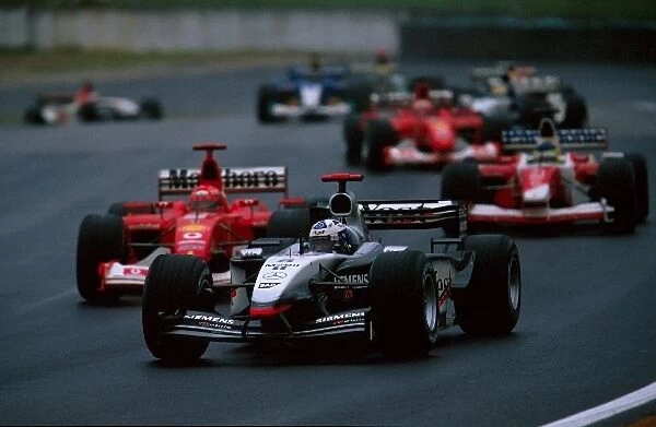 Formula One World Championship: Fourth placed David Coulthard McLaren Mercedes MP4 / 17D leads Michael Schumacher Ferrari F2002, who crashed out