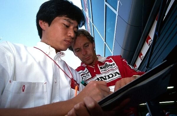 Formula One World Championship: Gerhard Berger McLaren confers with the Honda engineers in the pits