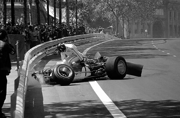 Formula One World Championship: Graham Hill climbs from the wreckage of his Lotus 49B, his rear wing having collapsed on the ninth lap