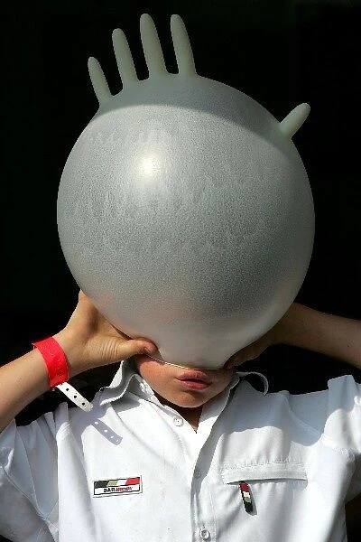 Formula One World Championship: Harry, the son of David Richards BAR Team Principal inflates a rubber glove on his head