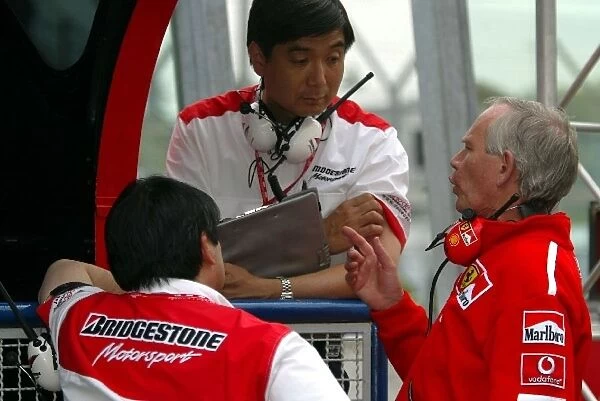 Formula One World Championship: Hisao Suganama Bridgestone talks with Rory Byrne Ferrari Chief Designer