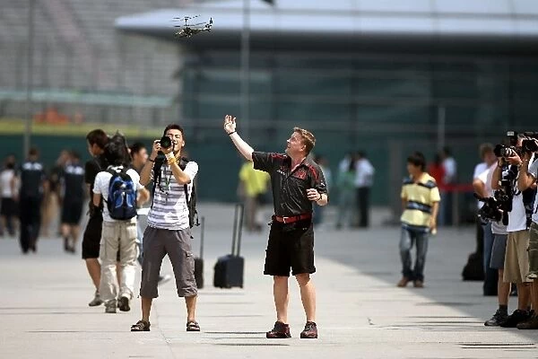 Formula One World Championship: Honda mechanics play with a helicopter in the paddock