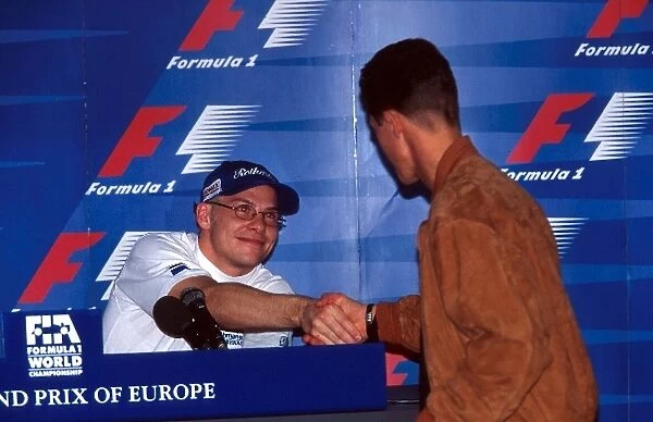 Formula One World Championship: Jacques Villeneuve Williams FW19 and Michael Schumacher Ferrari F310B shake hands before the race