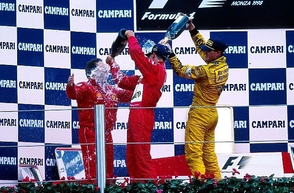 Formula One World Championship: Jean Todt Ferrari receives a soaking from Winner Michael Schumacher and Ralf Schumacher Williams