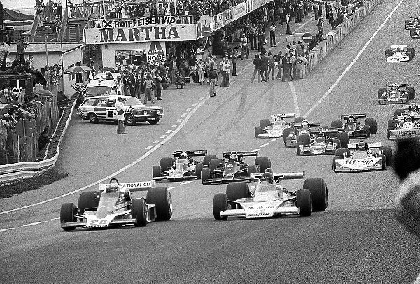 Formula One World Championship: John Watson Penske PC4 pulls ahead of pole sitter and fourth placed finisher James Hunt McLaren M23 at the start of the race