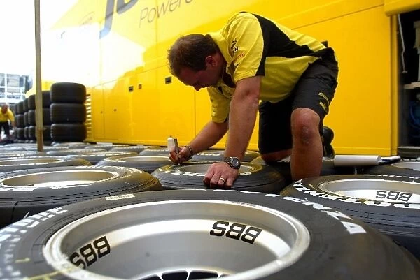 Formula One World Championship: A Jordan mechanic marks up tyres for the weekend ahead
