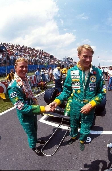 Formula One World Championship: Lotus 107 team mates Johnny Herbert and Mika Hakkinen shake hands before the start on the grid