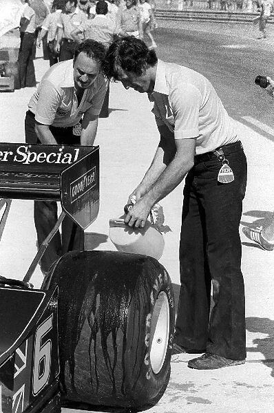 Formula One World Championship: A Lotus mechanic pours water onto the rear tyre of the Lotus 78 of pole sitter Ronnie Peterson, who retired