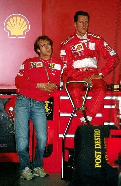 Formula One World Championship: Luca Badoer Ferrari Test Driver and Michael Schumacher in the pit garage