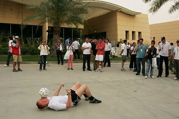 Formula One World Championship: A man demontrates football skills in the paddock