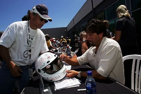 Formula One World Championship: Mario Andretti and son Michael Andretti signs autographs for the fans