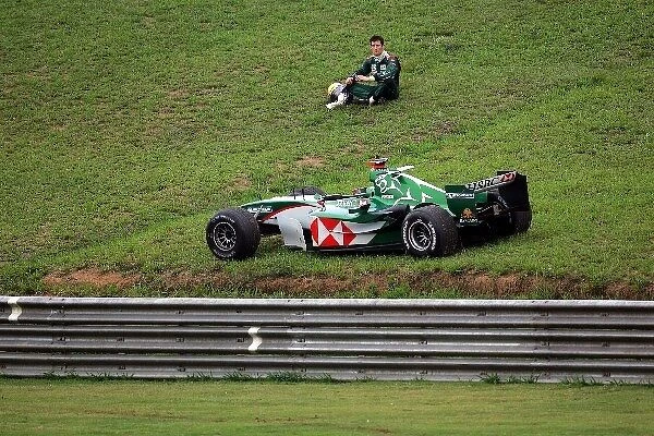 Formula One World Championship: Mark Webber Jaguar sits by the side of the track after colliding with his team mate in the race