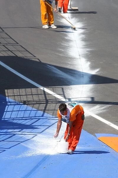 Formula One World Championship: A marshal cleans oil off the track after Sebastian Vettel Red Bull Racing RB5 suffered and engine failure during