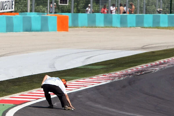 Formula One World Championship: Marshal clears some debris from turn 1 at the start of the race