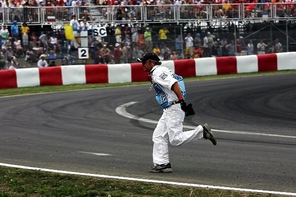 Formula One World Championship: A marshall clears debris from the track