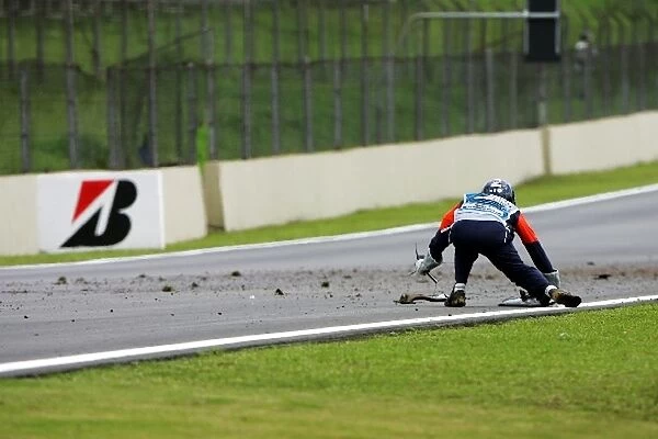 Formula One World Championship: Marshals clear debris of Kazuki Nakajima Williams FW31 crash from the circuit