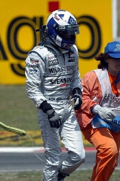 Formula One World Championship: Marshals help David Coulthard McLaren after he spun into the gravel trap