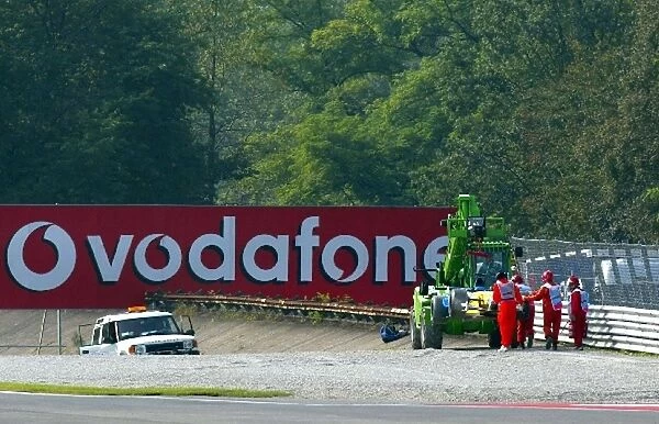 Formula One World Championship: Marshals remove the Renault R202 of Jenson Button from the gravel trap at Parabolica