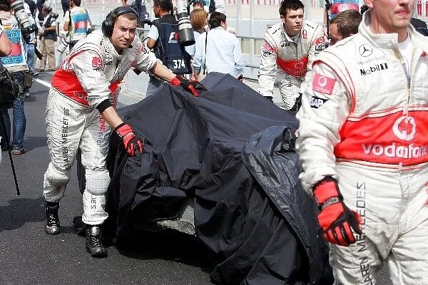 Formula One World Championship: McLaren bring the damaged car of Heikki Kovalainen McLaren back to the garage